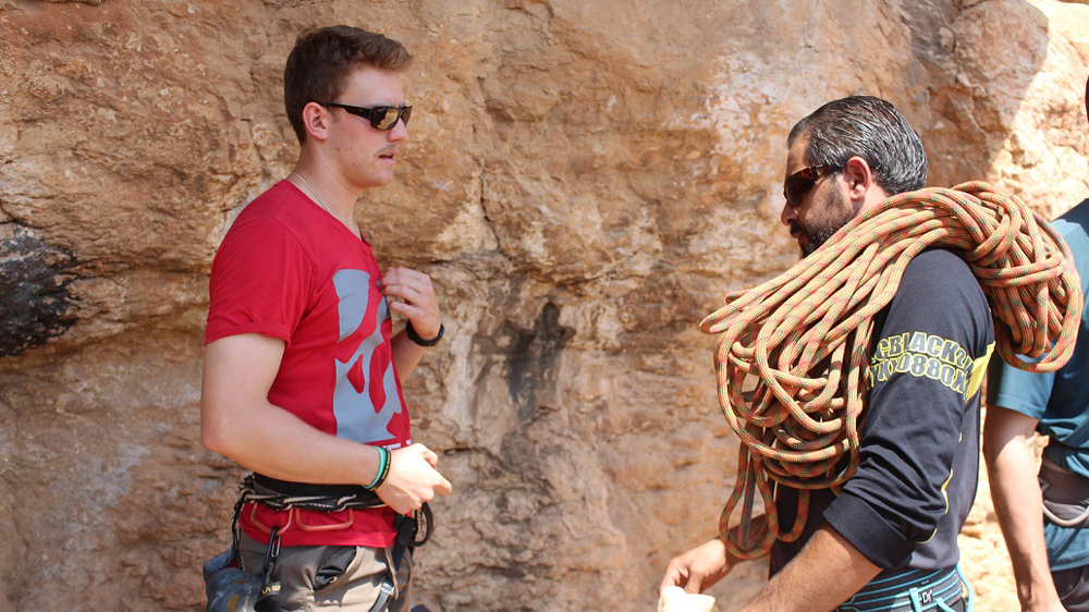 Wadi Climbing co-founder Will Harris speaks with a climber near Ein Qiniya village [Nigel Wilson/Al Jazeera]
