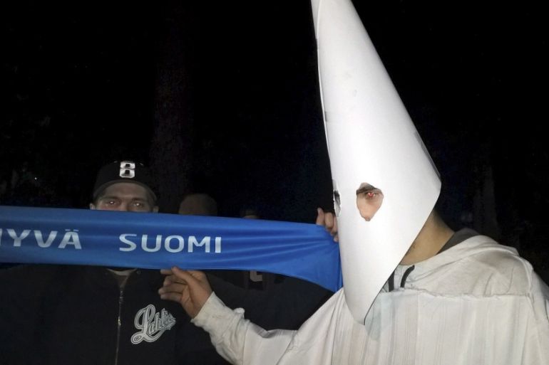 A demonstrator wearing a Ku Klux Klan outfit attends a protest against refugees in Lahti, Finland