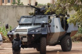 Presidential guard soldiers are seen on an armoured vehicle at Laico hotel in Ouagadougou, Burkina Faso