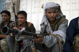 Pro-government militants sit on the side of a street where they fight against Houthi militia men in Yemen''s southwestern city of Taiz