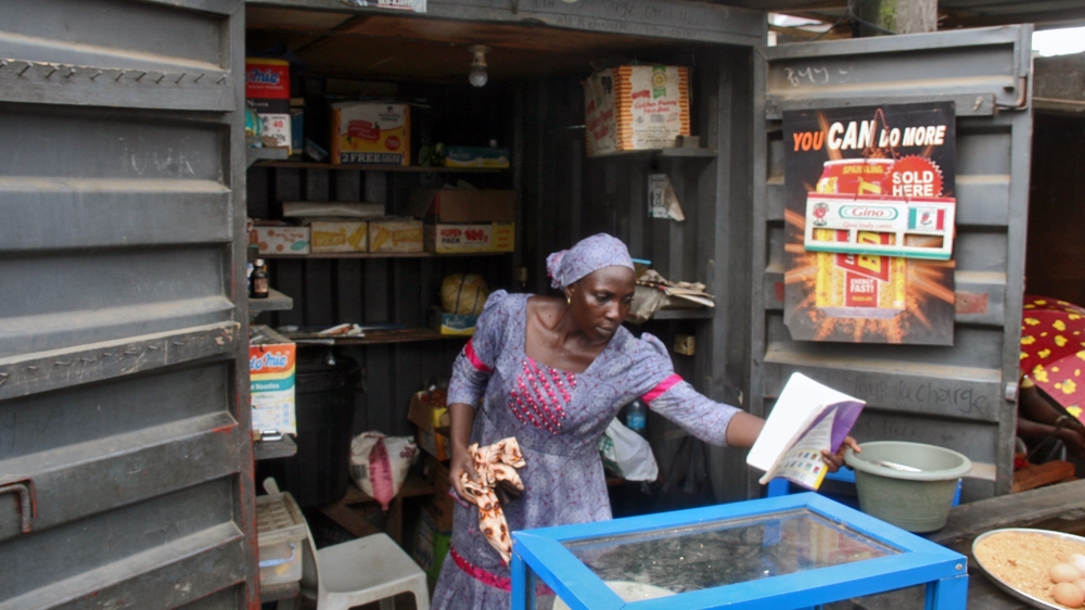Kafayat’s shop is in an old shipping container. She has very little stock and has to use empty boxes to make the shelves appear more full [Abiodun Omotosho/Al Jazeera]