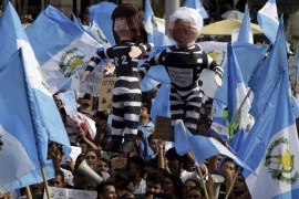File photo of demonstrators waving Guatemalan national flags and holding effigies representing Guatemala''s President Perez Molina and former Vice President Baldetti, during a prot