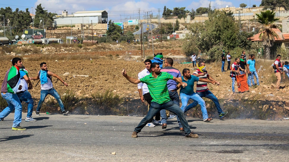 Palestinian protesters threw rocks while Israeli forces fired ammunition during a protest in support of Al-Aqsa near Ramallah [Muhannad Drabee/Al Jazeera]