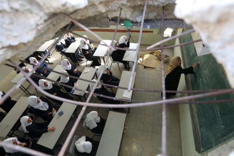Palestinians schoolgirls attend a lesson on the first day of a new school year at Suhada Khouza school in Khan Younis