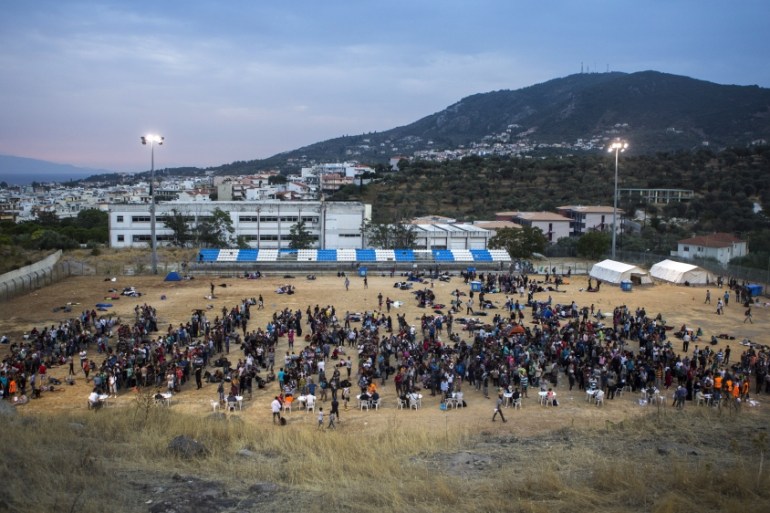 Refugees and migrants wait for their registration