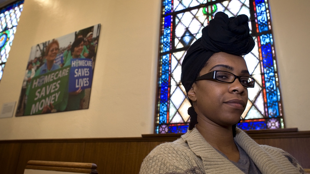 Community activist Kim Moore poses for a photograph in the church that houses the United Domestic Workers' office [David Maung/Al Jazeera]