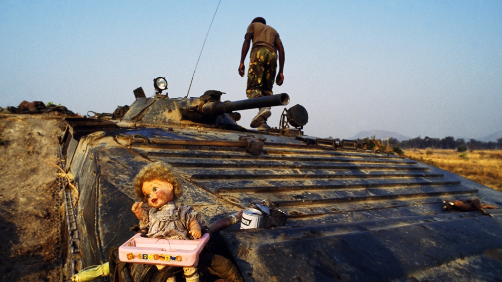 Angola's MPLA soldiers would often carry amulets or decorate their tanks for good luck. In this case it was with a child's doll. It seemed visually and culturally incongruous. 1994 [Jack Picone] 