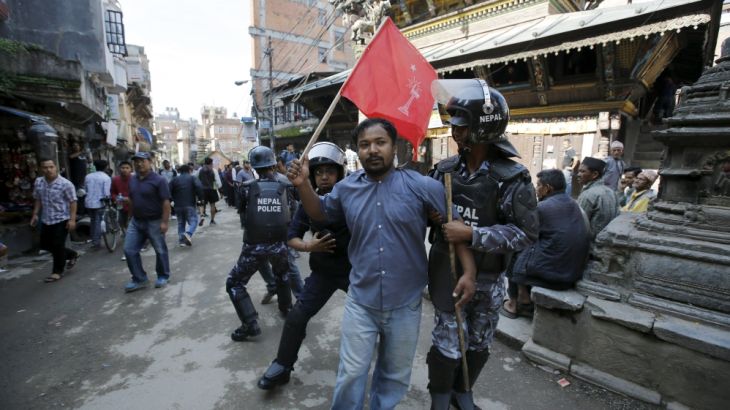 Nepalese riot police personnel detain an opposition supporter protesting against the proposed constitution during a nationwide strike called by the opposition parties in Kathmandu