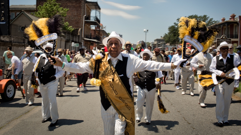 Norman L Thomas Sr, the grand marshal of the Zulu Social Aid and Pleasure Club, the oldest African American carnival krewe in New Orleans, leads a second line during the Louis Armstrong Festival. When asked about the Confederate monuments, Thomas said: 'I ignore it. I knew it didn't stand for nothing for me' [Roopa Gogineni]