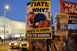 A man holds a placard with a photograph in Athens