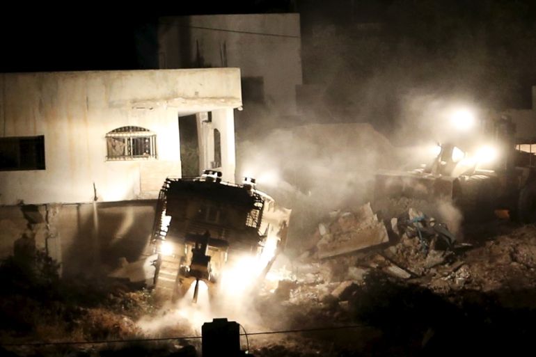 Israeli army machines demolish a Palestinian house during an Israeli raid in the West Bank city of Jenin