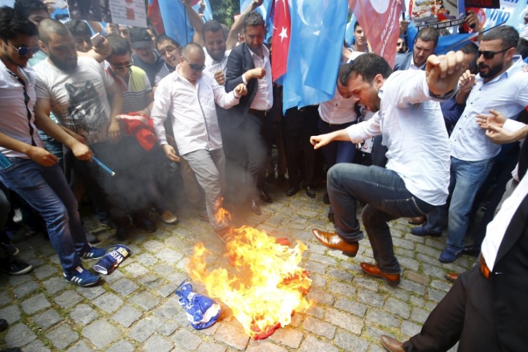 Demonstrators set fire to a Chinese flag during a protest against China near the Chinese Consulate in Istanbul