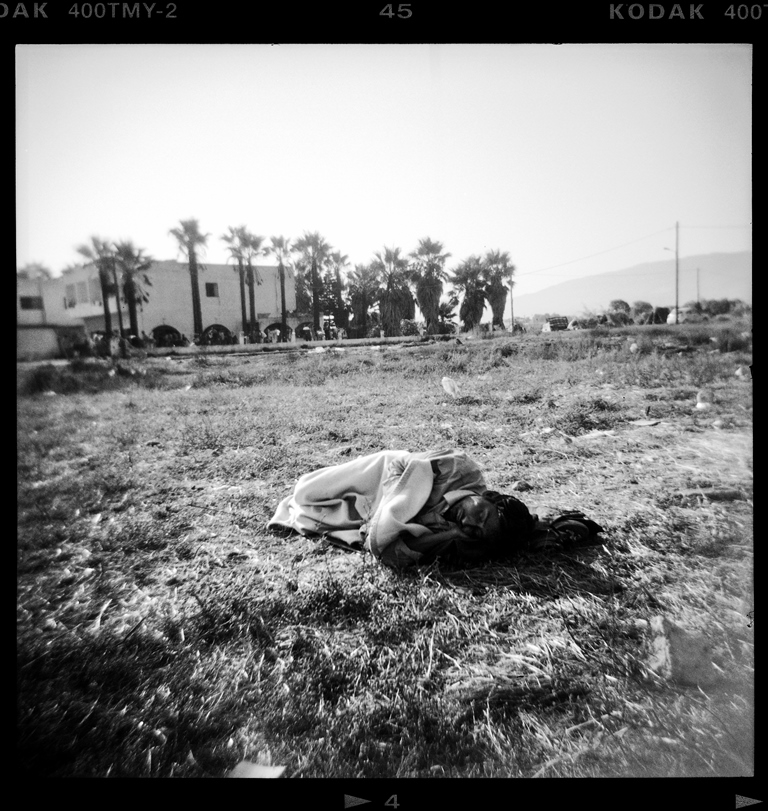 A man from Pakistan sleeps outside Captain Elias, an abandoned hotel used by the Greek authorities as an unofficial reception centre on the Greek island of Kos – Kos, Greece, August 2015 [Giorgos Moutafis] 