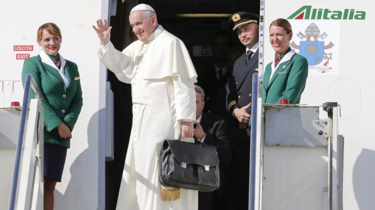 Pope Francis waves as he boards a plane at Fiumicino Airport in Rome