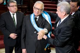 Alejandro Maldonado, the new Guatemalan President, receives the presidential sash from Rabbe, as lawmakers Fajardo and Herrera, look on during a sworn in ceremony at the Congress in Guatemala City