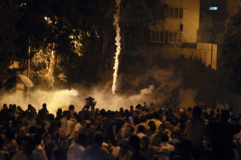 Protesters flee from tear gas during clashes front of the Israeli embassy in Cairo