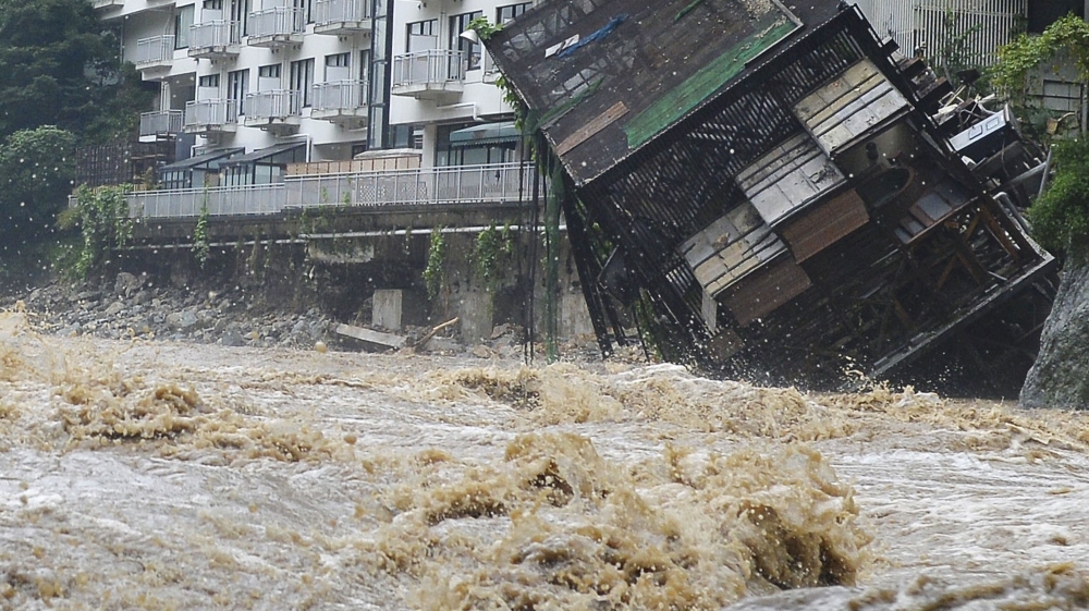 The building of an open-air spa, right, that belongs to Kinugawa Plaza Hotel, falls into the rapid stream of the Kinugawa River swollen by heavy rainfall in Nikko, northeast of Tokyo [Kyodo News/AP]