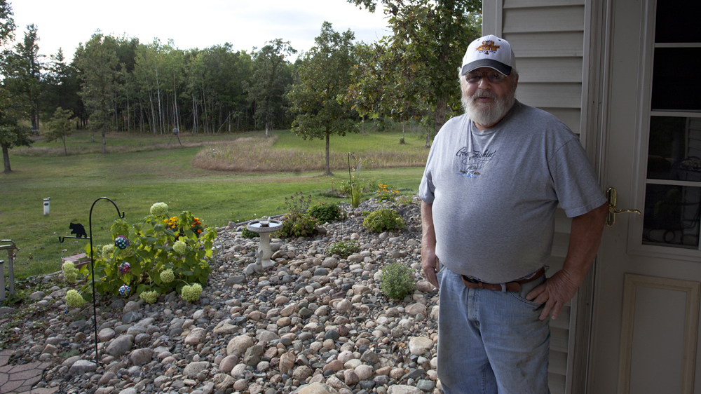 Bob Scribner stands in front of his home near Long Lake in Hubbard Count, Minnesota [Sadie Luetmer/Al Jazeera]