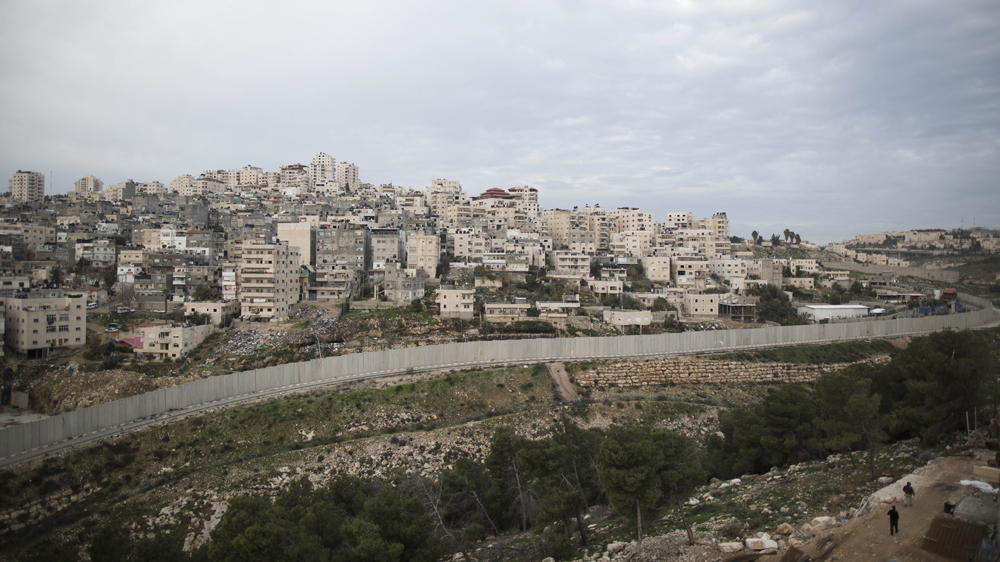A view of the Palestinian refugee camp of Shuafat surrounded by the Israeli separation barrier dividing the Palestinian refugee camp of Shuafat from the Jewish settlement of Pisgat Ze'ev [Abir Sultan/EPA]