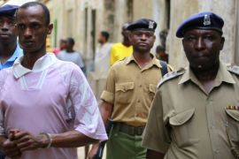 Ali Babitu Kololo is escorted by police to the cells after he was sentenced to death for robbery with violence charges and seven years for participating in the kidnap of British tourists in Lamu