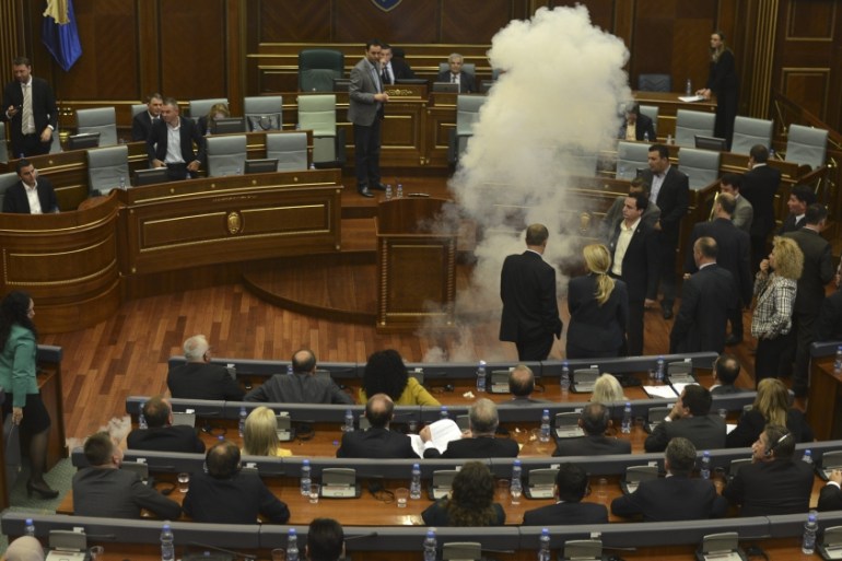 Opposition lawmakers throw tear gas during a session of Kosovo''s parliament.