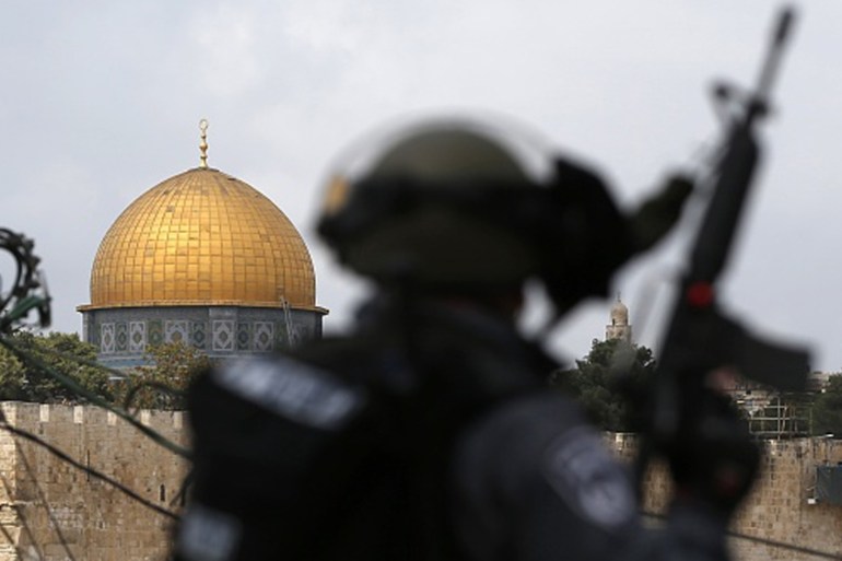 Israeli security forces stand guard as Palestinian Muslim worshippers take part in Friday noon prayers in the east Jerusalem neighbourhood of Ras al-Amud [Getty]