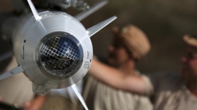Russian military support crew inspects missiles attached to their jet at an airbase in Syria [AP]