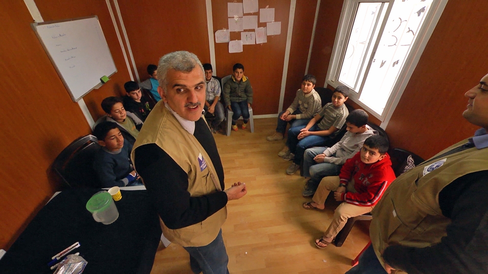Dr Abo-Hilal directs a visualisation session with young Syrian children [Dan McKinney/Al Jazeera]