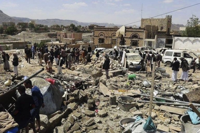 People gather at the site of Saudi-led airstrikes in Sanban