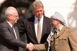 US President Bill Clinton stands between PLO leader Yasser Arafat and Israeli Prime Minister Yitzahk Rabin as they shake hands 13 September 1993 at the White House in Washington DC [AFP]