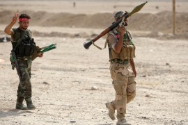 A Shiite fighter carries a rocket-propelled grenade in Baiji, Iraq
