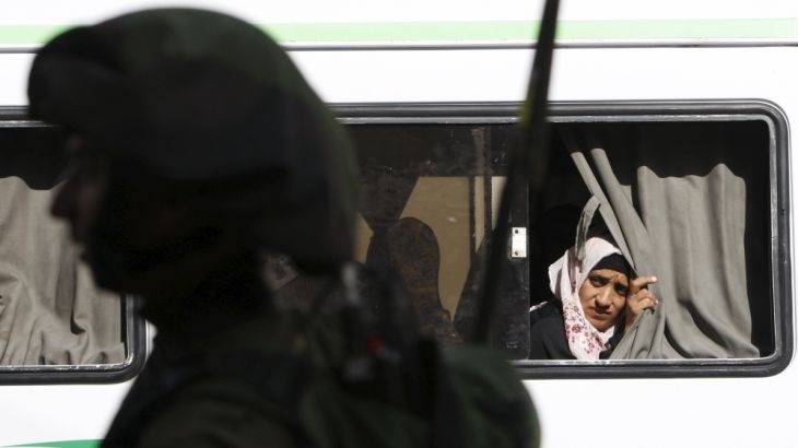 A Palestinian woman looks out of a bus window during clashes between Palestinians protesters and Israeli troops in the occupied West Bank city of Hebron