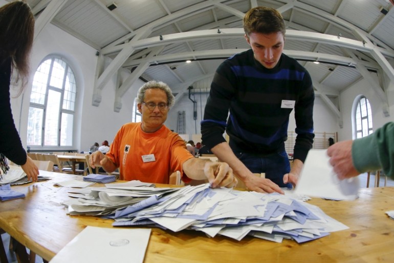 Members of an election office sort ballots in Zurich