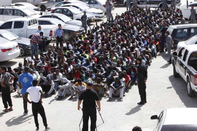 Illegal migrants sit at a temporary detention centre after they were detained by Libyan authorities in Tripoli