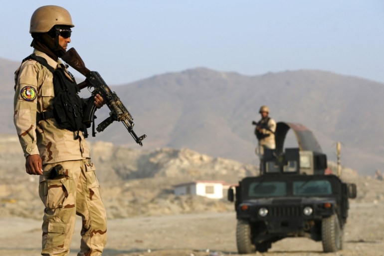 Afghan policemen stand guard at a checkpoint in the Deh Sabz district of Kabul, Afghanistan [REUTERS]