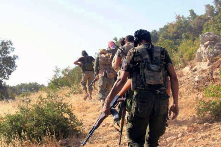 Fighters from the Ahrar al-Sham group walk toward army positions in the western Akrad Mountain region in the coastal province of Latakia, Syria [AP]