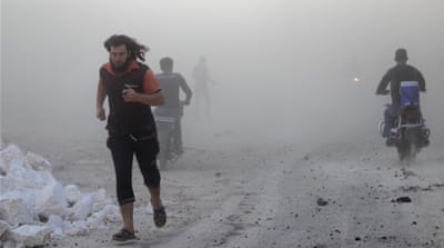 Residents run through dust in a site damaged by what activists said were air strikes carried out by the Russian air force in a rebel-controlled area in Idlib province [Reuters]