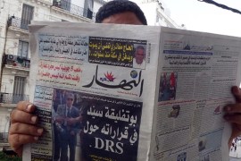 An Algerian man reads a local newspaper, En-Nahar, bearing a picture for the first time of former Algerian intelligence chief General Mohamed Mediene, better known as General Toufik, on the front cove