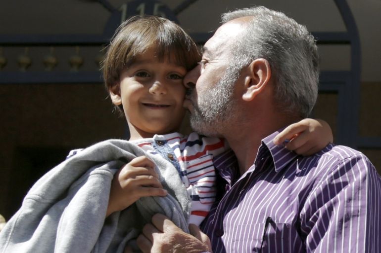 Osama Abdul Mohsen kisses Zaid after talking to reporters in front of their new home in Getafe, Spain