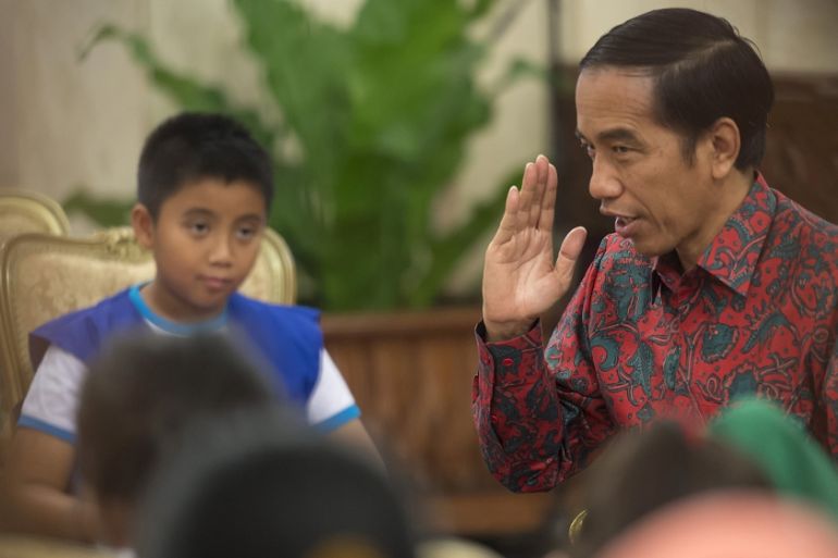 Indonesia President Joko Widodo gestures as he answers questions from representatives of elementary school students, playing the role of young reporters, at the Presidential Palace in Jakarta