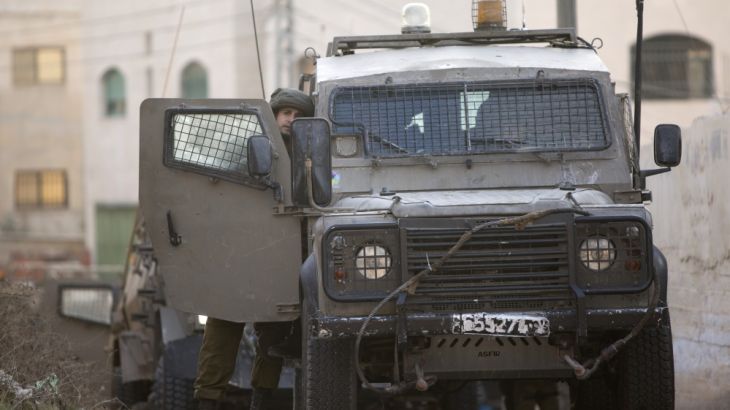 Israeli soldier stands by a vehicle during an Israeli military