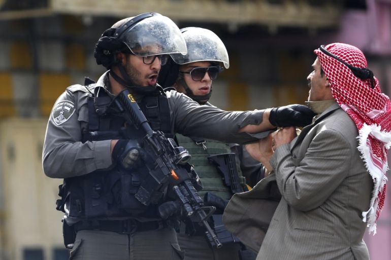 A Palestinian is pushed an Israeli policemen amid clashes in Hebron,