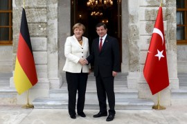Turkish Prime Minister Ahmet Davutoglu shakes hands with German Chancellor Angela Merkel before their meeting in Istanbul, Turkey