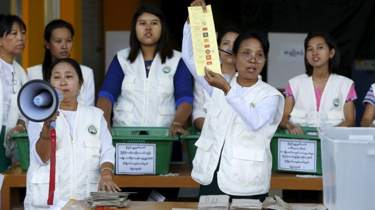 An election monitor holds up a vote for National League for Democracy (NLD) as the counting of advance votes take place at a polling station during the general election in Mandalay