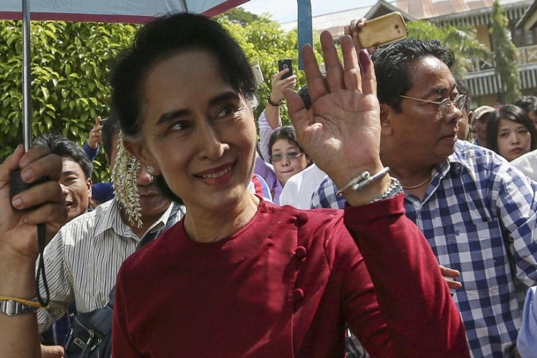 Myanmar pro-democracy leader Aung San Suu Kyi waves at supporters as she visits polling stations at her constituency Kawhmu township