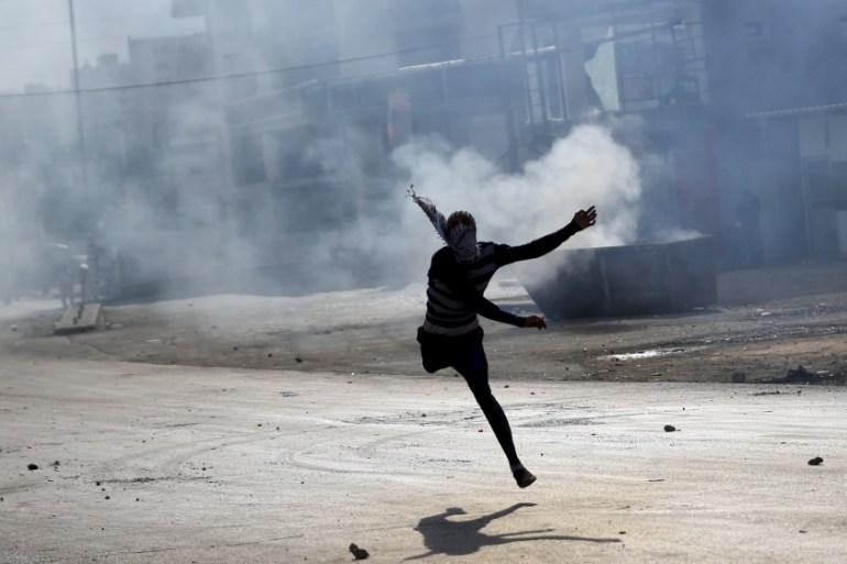 Palestinian protester hurls stones at Israeli troops during clashes near the Jewish settlement of Bet El, near the West Bank city of Ramallah