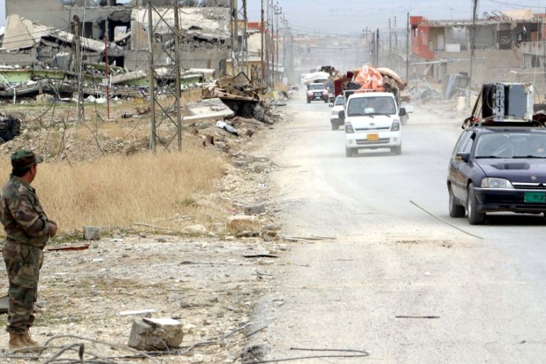 Yazidi people in vehicles loot the area of Sinjar