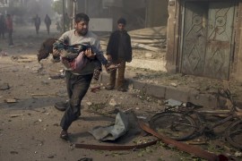 A man carries an injured girl as he rushes away from a site hit by what activists said were airstrikes by forces loyal to Syria''s President Bashar al-Assad, in Douma