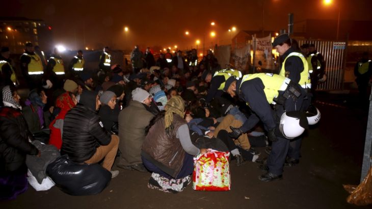 Police officers evict migrants from an illegal camp in Sweden
