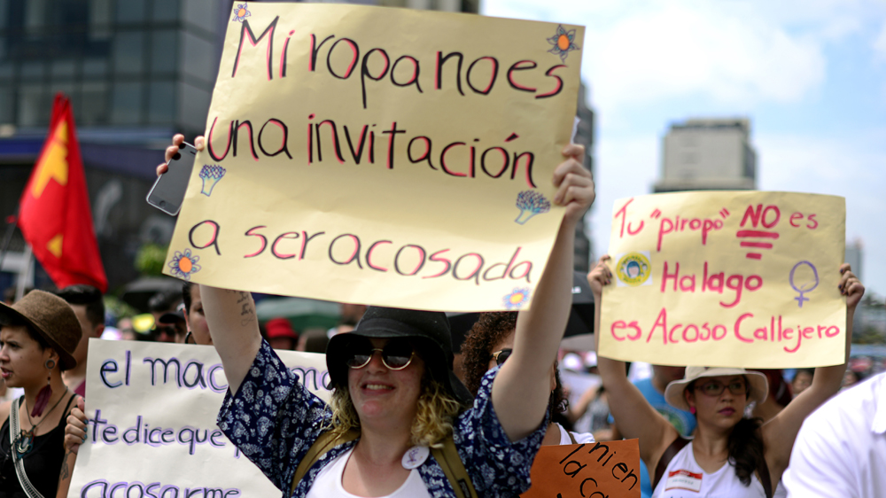 'My outfit is not an invitation to harassment,' reads a sign during an anti-sexual harassment demonstration in Costa Rica [Lindsay Fendt/Al Jazeera]